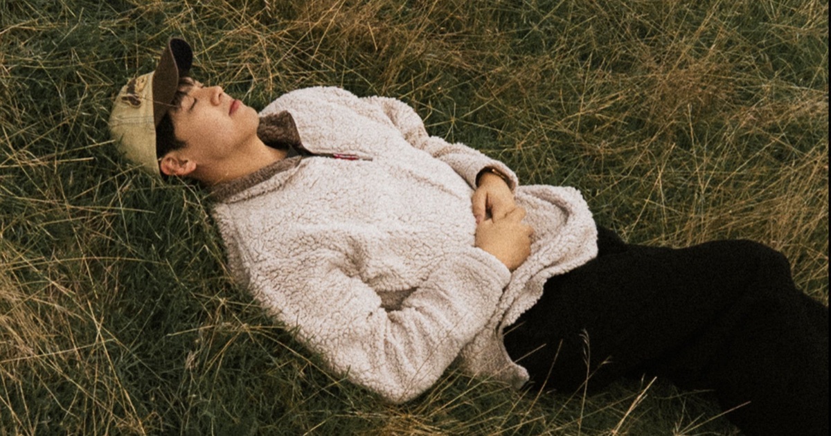 teem lying on grass in the official Esplanade artist photograph